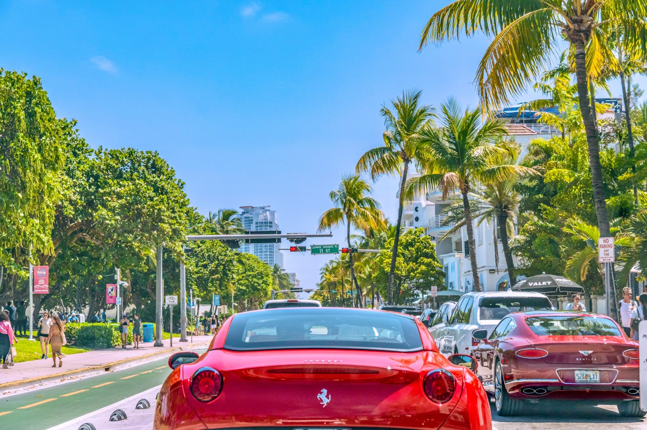 A panoramic view of Ocean Drive in Miami Beach featuring colorful Art Deco buildings, palm trees, and a lively street scene.