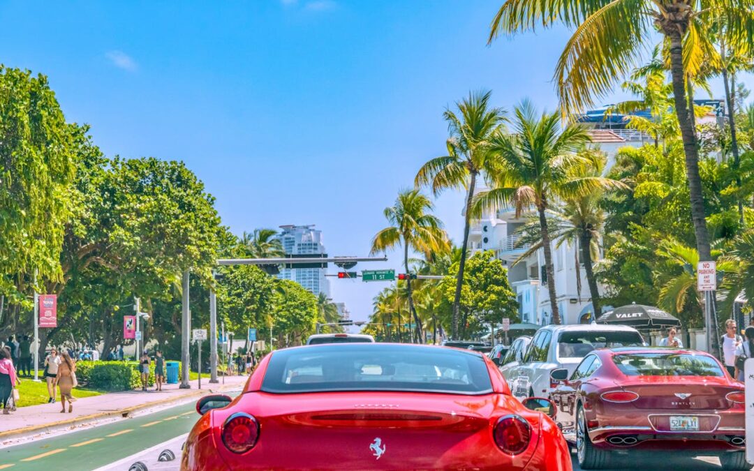 A panoramic view of Ocean Drive in Miami Beach featuring colorful Art Deco buildings, palm trees, and a lively street scene.